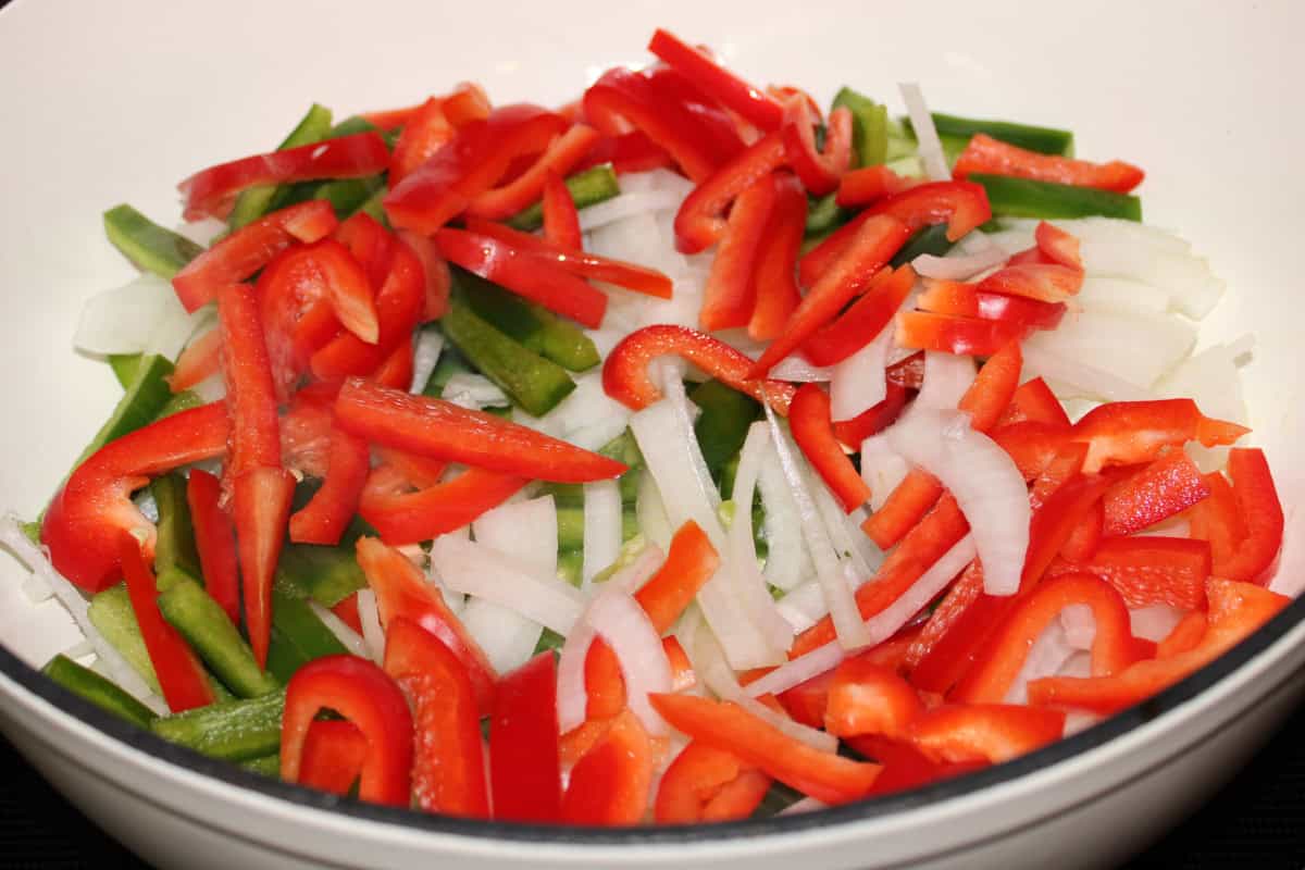 Sauteeing Red and Green Peppers with Onions in White Dutch Oven