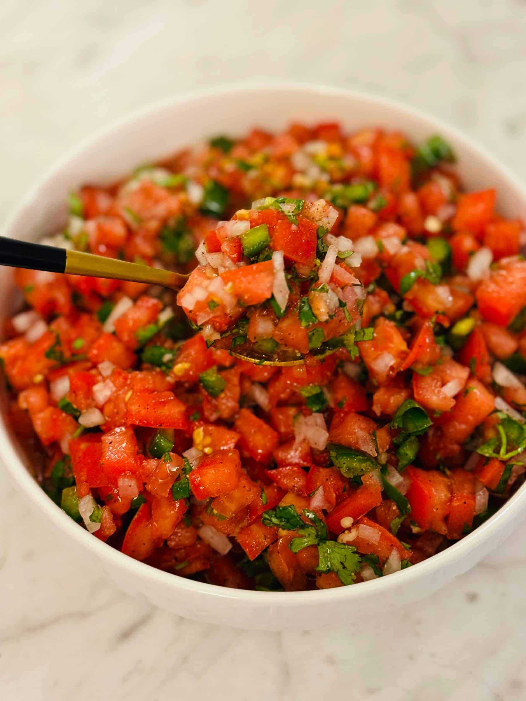 White bowl with Pico de Gallo with Golden Spoon